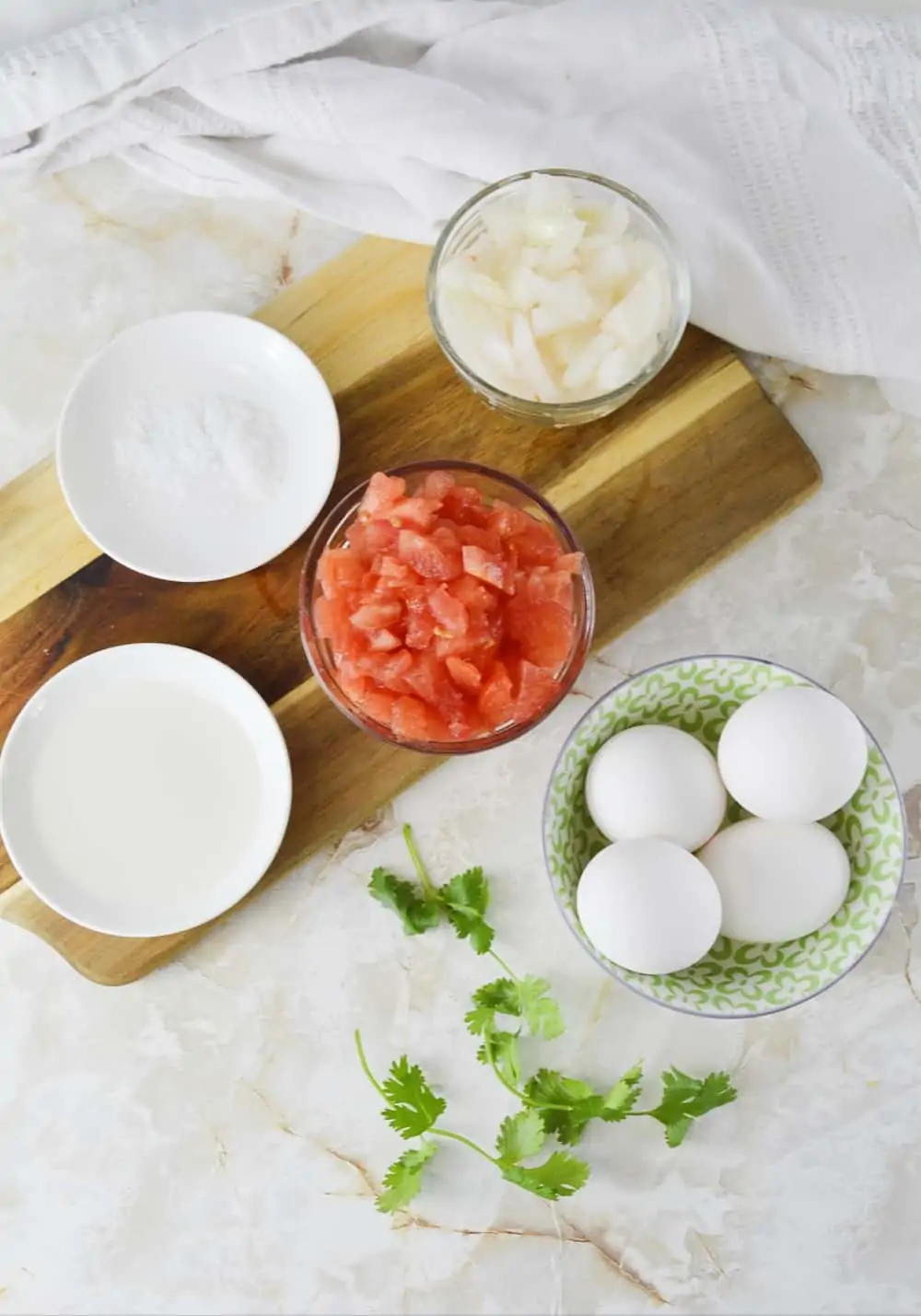 Ingredients for scrambled egg with tomato includes white onion, tomato, salt and cilantro ( optional).