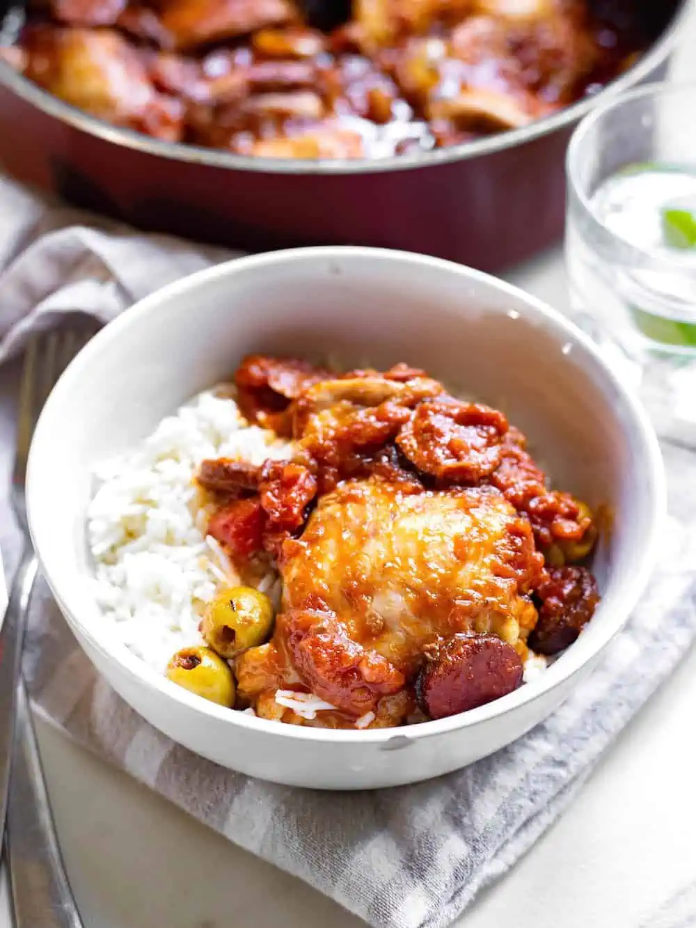 A bowl of pollo guisado Guatemalteco on a grey plaid napkin. Gu