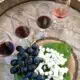 Four glasses of Turkish wines on a barrel with grapes and cheese. T