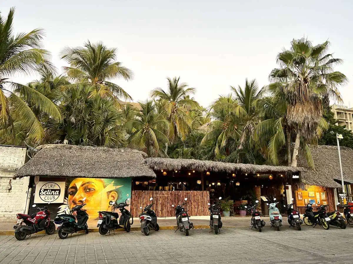 Exterior of Selina Hostel in Puerto Escondido, Mexico with scooters parked in front. 