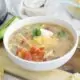 Bowl of Slow Cooker Chipotle Chicken soup on a wooden board.