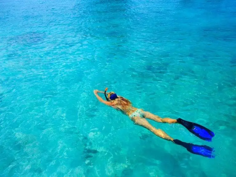 Woman snorkelling in blue water in Freeport, Bahamas.