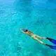 Woman snorkelling in blue water in Freeport, Bahamas.