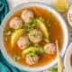 Sopa de albondigas in a bowl with a spoon.