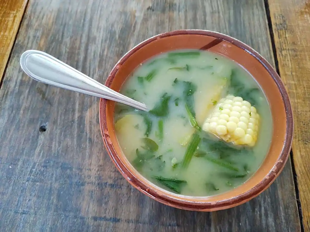 A bowl of Oaxacan sopa de guías on a wooden table.