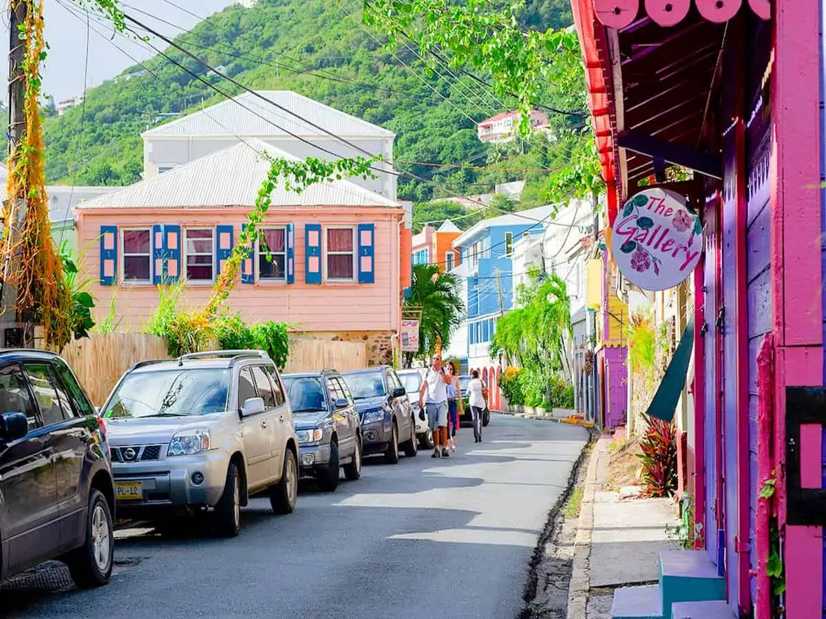 Narrow street in Road Town Tortola lined with pastel buildings.