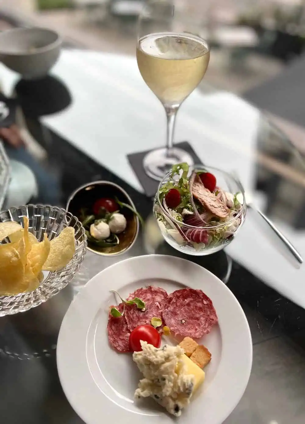Appetizers and a glass of white wine at The Level Melia Barcelona Sarria. 