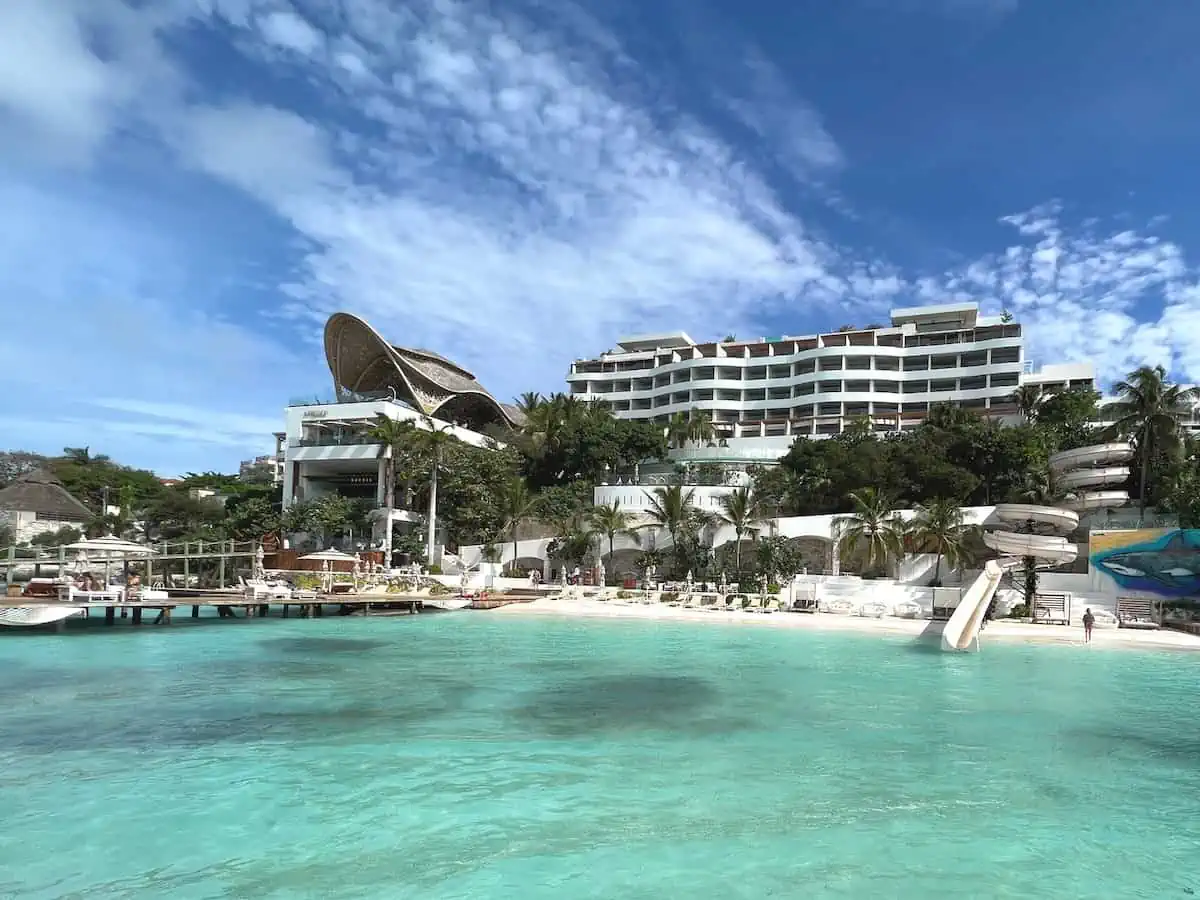 View of the Impression Isla Mujeres by Secrets private beach zone with water slide, hammocks and Bali beds. 