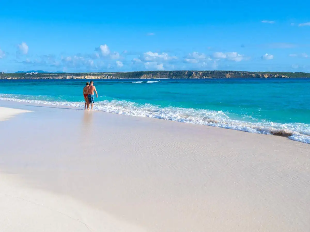 Two people walking into the ocean. 