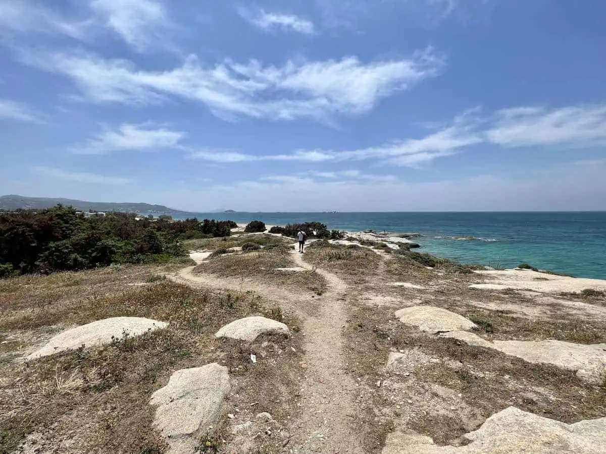 Man walking the path by the Aegean Sea towards Plaka. 