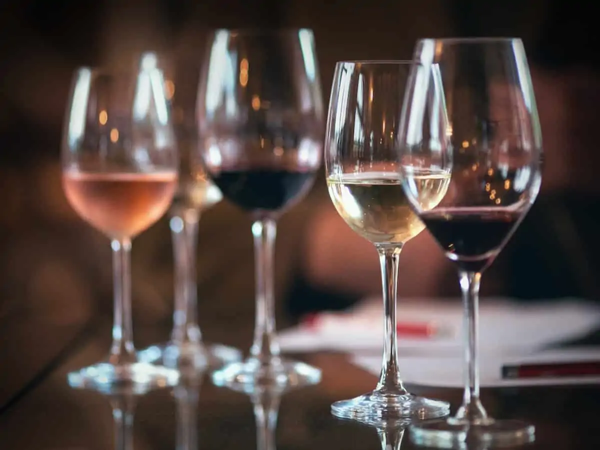 A variety of wines in glasses on a table.